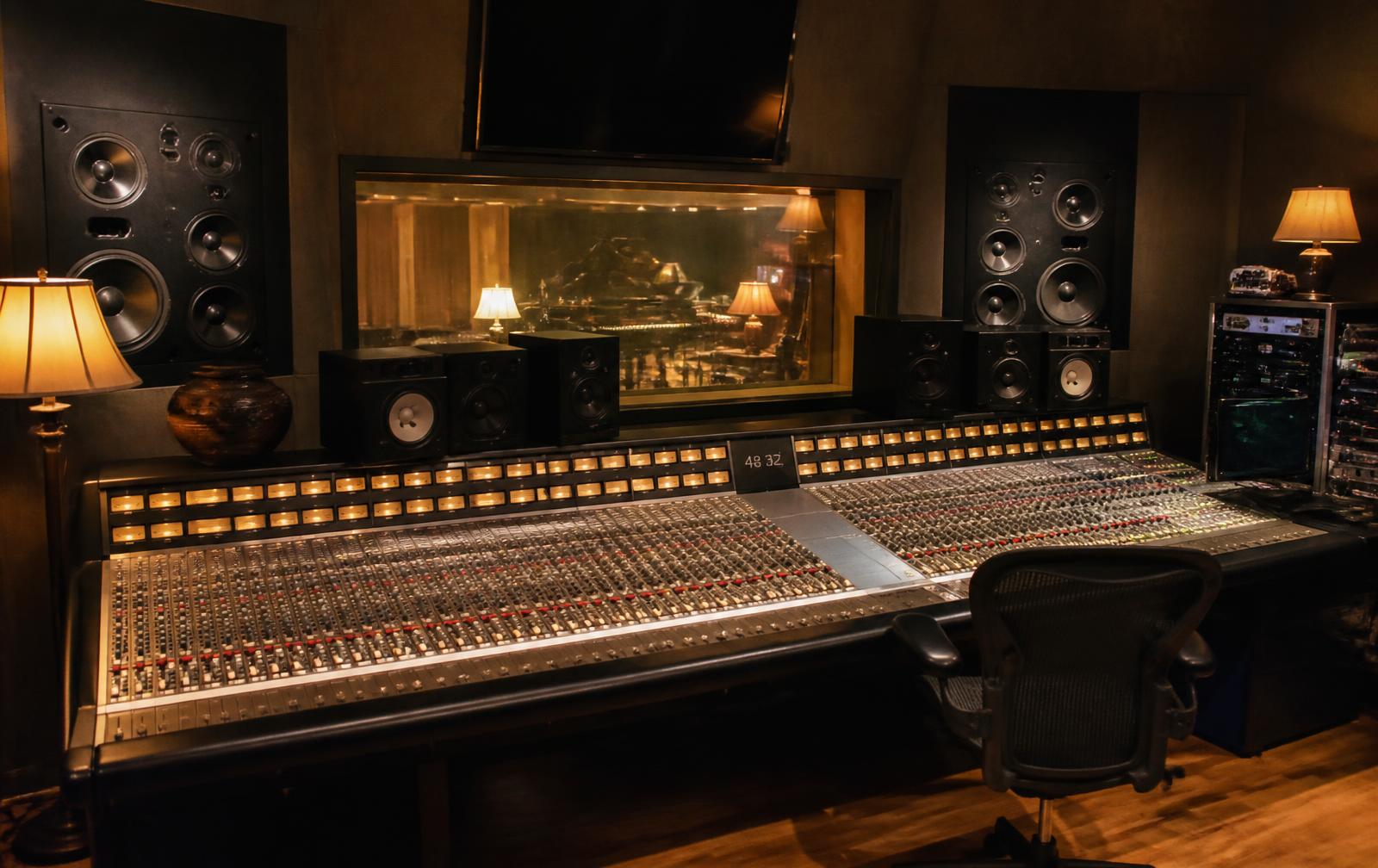 Professional music recording studio control room with a large analog mixing console